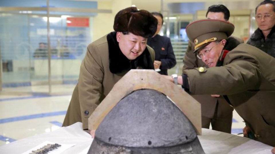 FILE PHOTO: KCNA file picture shows North Korean leader Kim Jong Un looking at a rocket warhead tip after a simulated test of atmospheric re-entry of a ballistic missile